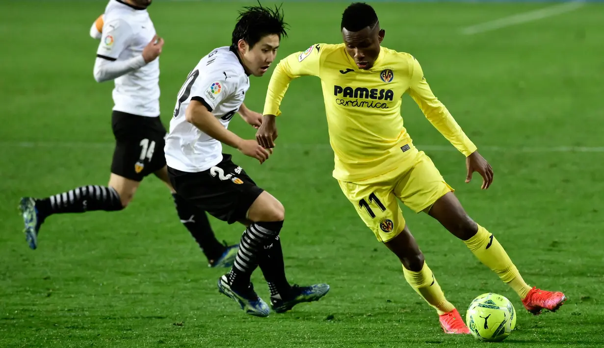 Gelandang Valencia, Kangin Lee (tengah) berusaha merebut bola dari gelandang Villareal, Samuel Chukwueze pada pertandingan lanjutan La Liga Spanyol di stadion Mestalla di Valencia (6/3/2021). Kemenangan dramatis itu membuat Valencia bertengger di peringkat ke-11 klasemen.  (AFP/Jose Jordan)