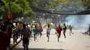 Demonstran berlari saat gas air mata dilepaskan polisi di kota Bishoftu, Ethiopia, Ahad (02/10). Pemerintah Ethiopia menyatakan 52 orang tewas dan banyak lainnya terluka. (REUTERS/Tiksa Negeri) 