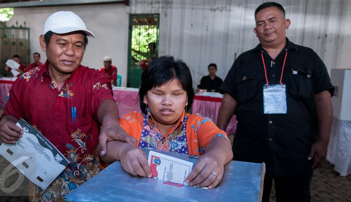 Penyandang disabilitas memasukan surat suara saat Pilkada DKI 2017 di TPS 07 Kelurahan Cawang, Jakarta, Rabu (15/2). KPU menggelar pemilihan umum kepala daerah secara serentak di 101 daerah pemilihan. (Liputan6.com/Gempur M Surya)