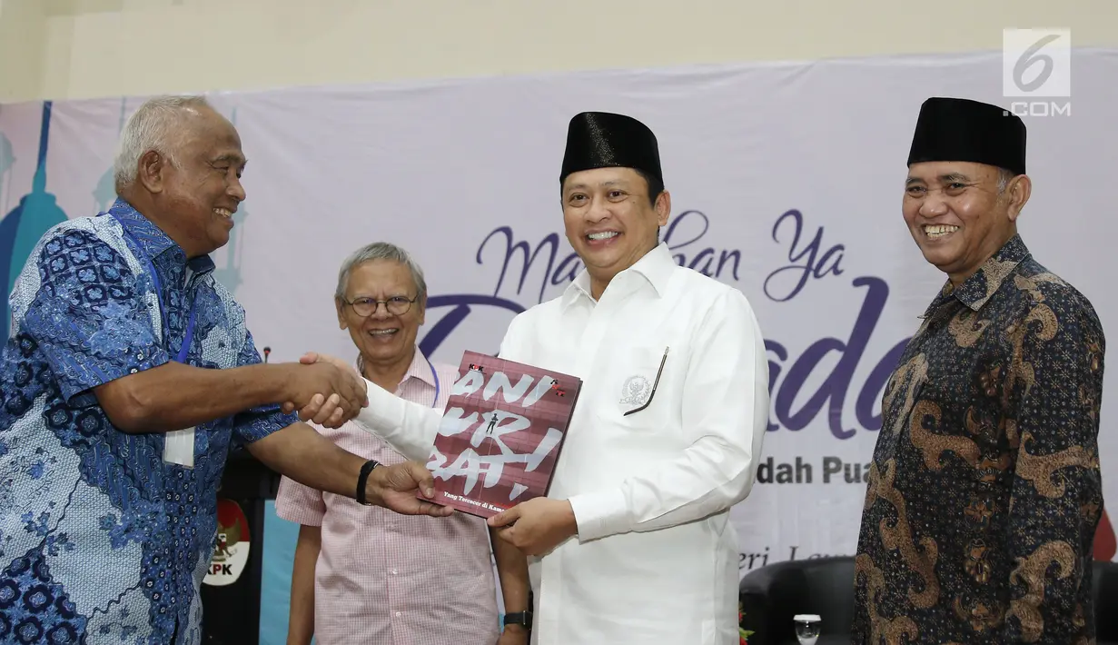 Mantan Ketua KPK Taufiqurrahman Ruki memberikan buku ke Ketua DPR RI Bambang Soesatyo saat peluncuran buku "14 Tahun Perjalanan KPK" di Gedung KPK, Jakarta (23/5). (Liputan6.com/Herman Zakharia)