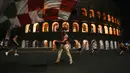 Suporter Italia mengibarkan bendara di depan Colosseum kuno Roma merayakan kemenangan atas Spanyol pada pertandingan semifinal Euro 2020, Roma, Rabu (7/7/2021). Gli Azzurri berhak ke final Piala Eropa 2020. (AP Photo/Alessandra Tarantino)