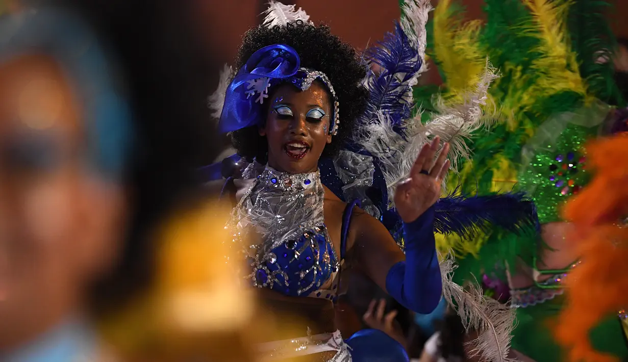 Anggota karnaval Uruguay, Comparsa, menari mengikuti irama musik selama parade karnaval Llamadas di Montevideo, Kamis (7/2). Karnaval terbesar di Uruguay ini menampilkan kelompok penari seksi dan musik tradisional selama dua hari. (PABLO PORCIUNCULA/AFP)