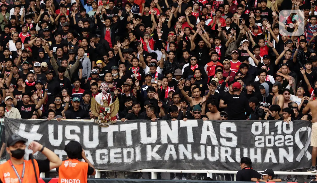 Pendukung timnas Indonesia membentang spanduk bertuliskan “Usut Tuntas” saat menyaksikan laga kualifikasi Grup A Piala AFF 2022 antara Indonesia melawan Kamboja di di Stadion Utama Gelora Bung Karno, Jakarta, Jumat (23/12/2022). Mereka menyuarakan pengusutan tuntas kasus atas Tragedi Kanjuruhan yang terjadi pada awal Oktober 2022 lalu. (Liputan6.com/Helmi Fithriansyah)