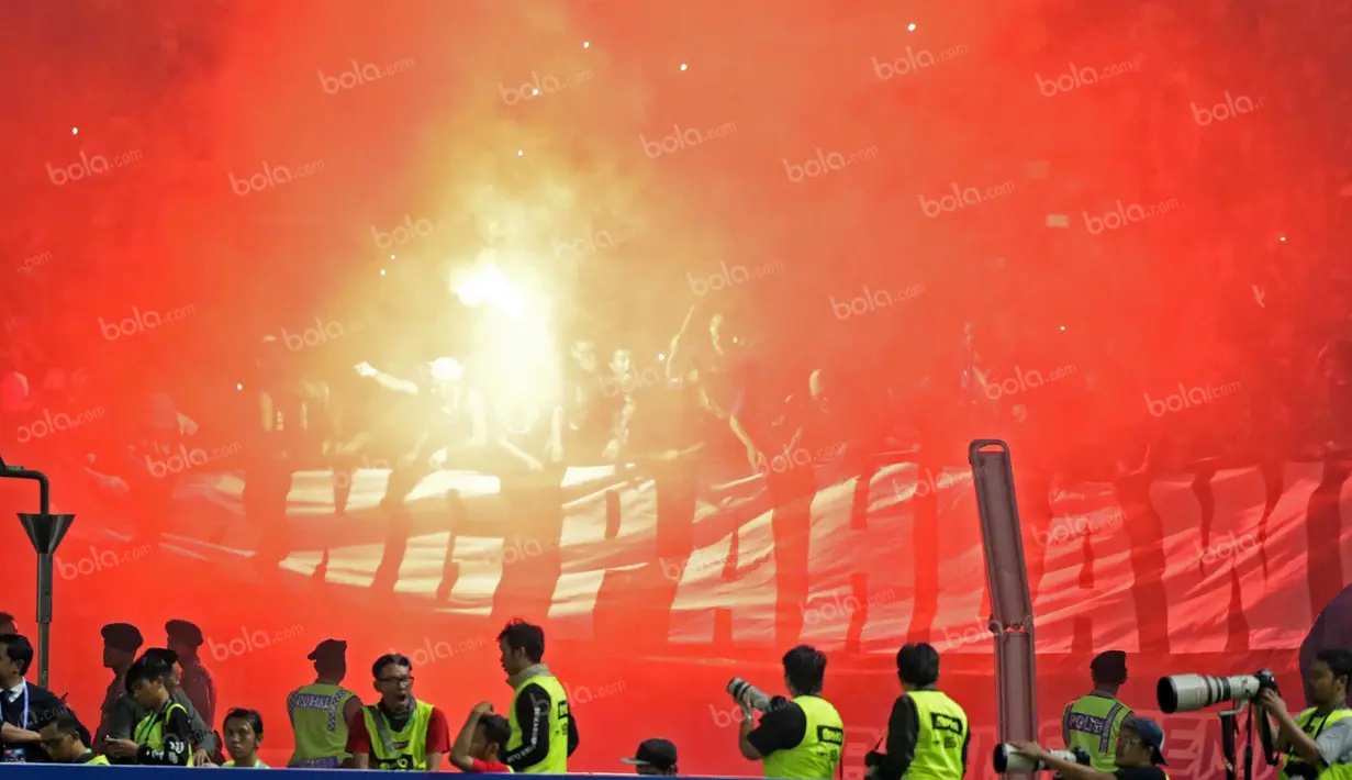 Aremania menyalakan flare sesaat setelah timnya meraih juara Torabika Bhayangkara Cup 2016 di Stadion Utama Gelora Bung Karno, Jakarta, Minggu (3/4/2016). (Bola.com/Nicklas Hanoatubun)
