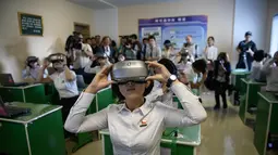 Sejumlah siswi menggunakan kacamata VR saat mengikuti kegiatan belajar di kelas di perguruan tinggi guru di Pyongyang, Kora Utara, Jumat (7/9). (AFP Photo/Ed Jones)
