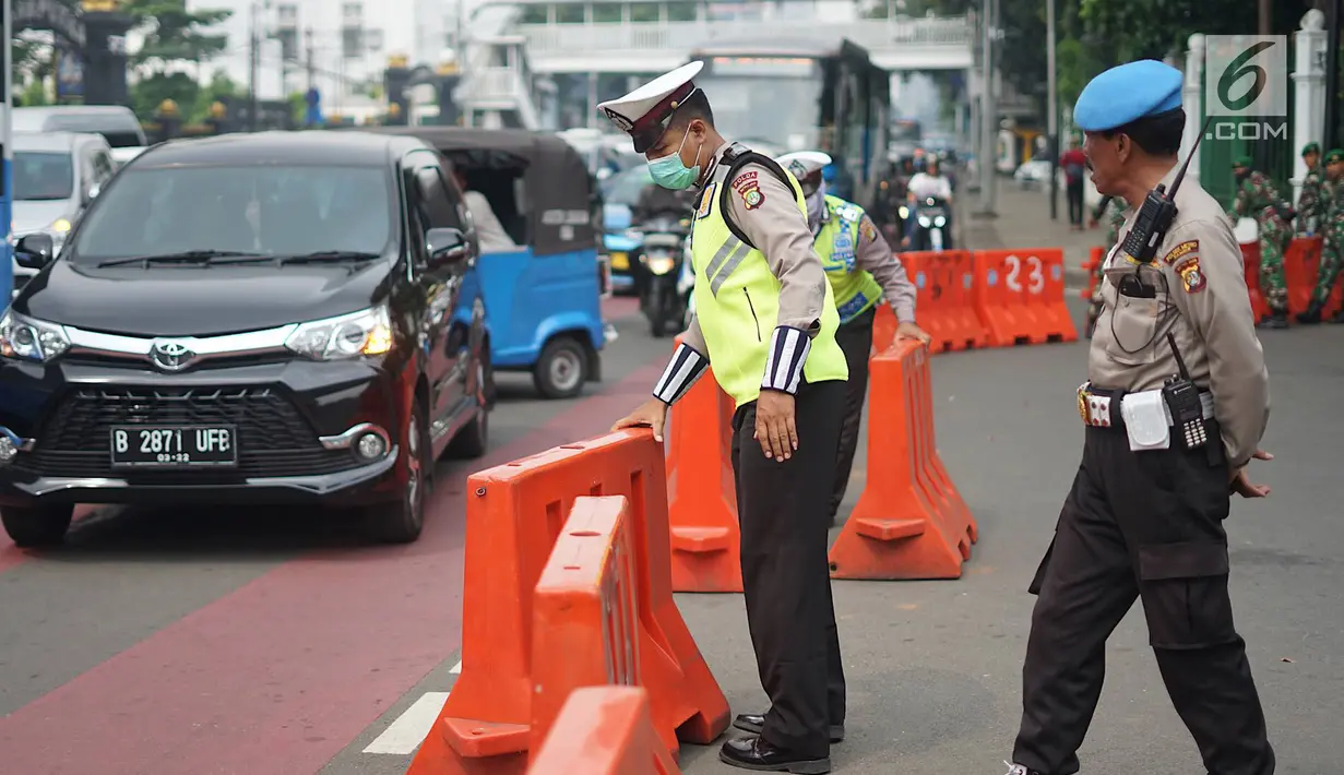 Petugas kepolisian menutup akses menuju Jalan Medan Merdeka Timur, Jakarta, Jumat (14/6/2019). Pengalihan arus dilakukan di sejumlah titik menuju Gedung Mahkamah Konstitusi terkait sidang perdana sengketa Pilpres 2019. (Liputan6.com/Immanuel Antonius)