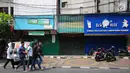 Pejalan kaki melintas di depan sejumlah pertokoan yang tutup di Jalan Sabang, Jakarta pada Rabu (22/5/2019). Pemilik toko dan pengelola kantor di kawasan tersebut menutup toko dan kantor mereka imbas aksi 22 Mei 2019 yang berakhir rusuh di beberapa titik lokasi. (Liputan6.com/Aangga Yuniar)