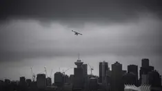 Sebuah pesawat amfibi lepas landas dari pelabuhan di bawah awan rendah di atas cakrawala pusat kota, di Vancouver, British Columbia, Kamis, (6/8/2020). (Darryl Dyck / The Canadian Press via AP)