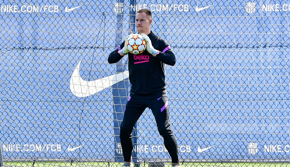 Penjaga gawang Barcelona, Marc-Andre ter Stegen menangkap bola saat mengambil bagian dalam sesi latihan di Barcelona, Spanyol (1/11/2021). Barcelona saat ini masih tertahan di peringkat ketiga klasemen Grup E Liga Champions dengan raihan tiga poin. (AFP/Pau Barrena)