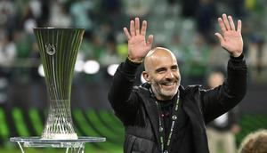 Pelatih Chelsea, Enzo Maresca, melambaikan tangan kepada suporter di dekat trofi UEFA Conference League yang diraih tim asuhannya setelah mengalahkan Real Betis dengan skor 4-1 di laga final yang berlangsung pada Kamis (29/5/2025) dini hari WIB. (AP Photo/Denes Erdos)