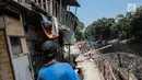 Sejumlah rumah hampir ambruk akibat amblesnya tanah di bantaran Anak Kali Ciliwung di Jalan Lodan Raya, Pademangan, Jakarta, Senin (19/11). Sudin SDA Jakarta Utara melakukan penguatan dinding kali untuk menahan longsor. (Liputan6.com/Faizal Fanani)