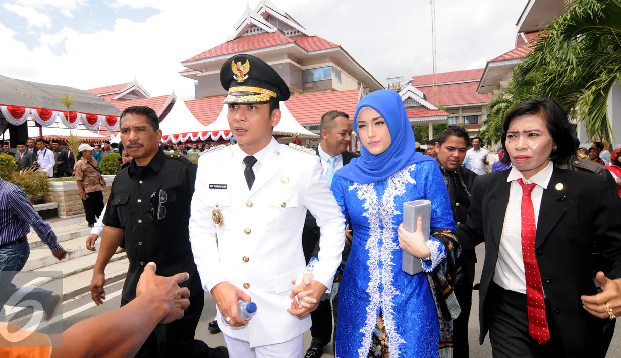  Sigit Purnomo Said atau akrab disapa Pasha Ungu mengggandeng erat tangan istrinya Adelia Pasha usai dilantik menjadi Wakil Wali Kota Palu periode 2016-2021 di halaman kantor itu, Rabu (17/2). (Liputan6.com/Dio Pratama)