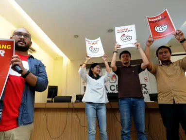 Sejumlah aktivis Koalisi KawalPilkada mengangkat poster usai memberikan pernyataan kepada wartawan di Gedung KPU Pusat, Jakarta, Senin (9/11/2015). Koalisi KawalPilkada mengembangkan website untuk mengawal proses Pilkada. (Liputan6.com/Helmi Fithriansyah)