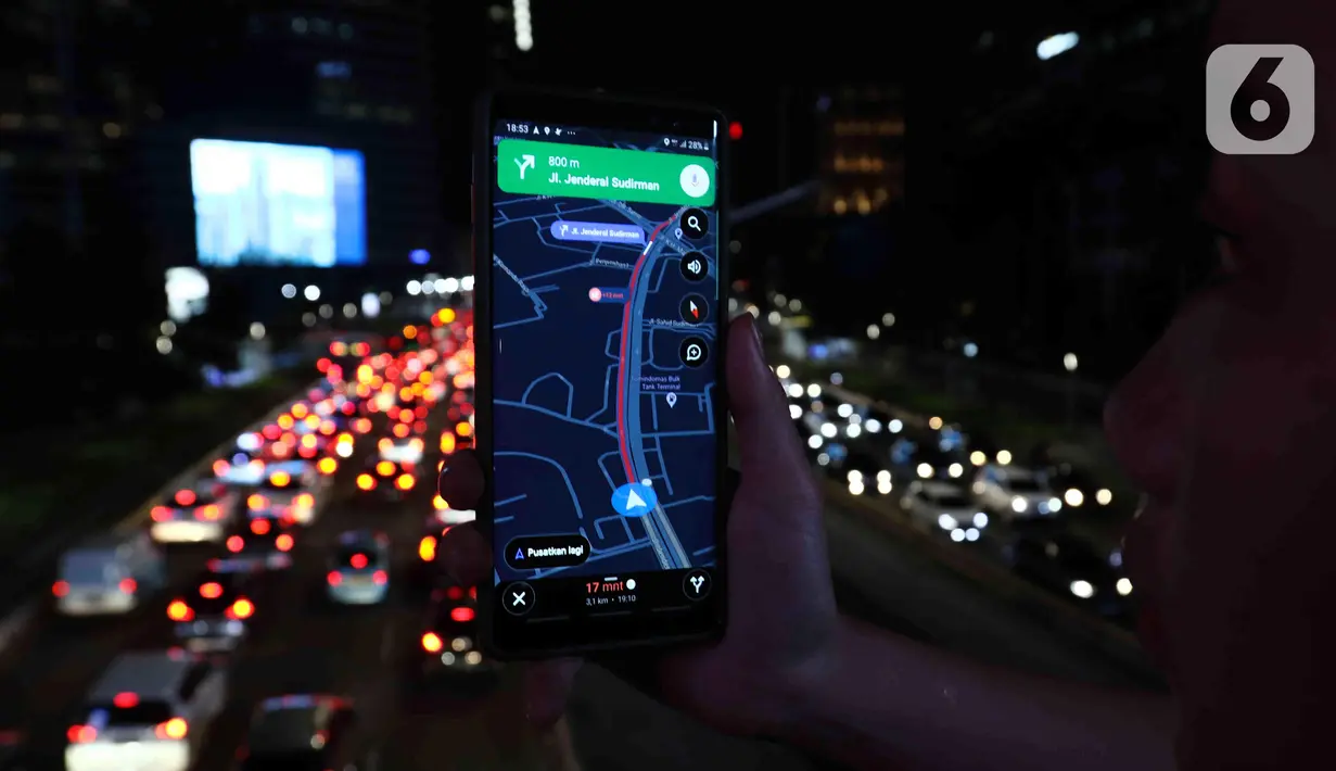 Warga mengoperasikan gawainya saat kemacetan terjadi di Jalan Jenderal Sudirman, Jakarta, Kamis (31/3/2022). Jalan Jenderal Sudirman terpantau mulai padat saat jam pulang kantor pada PPKM Level 2. (Liputan6.com/Herman Zakharia)