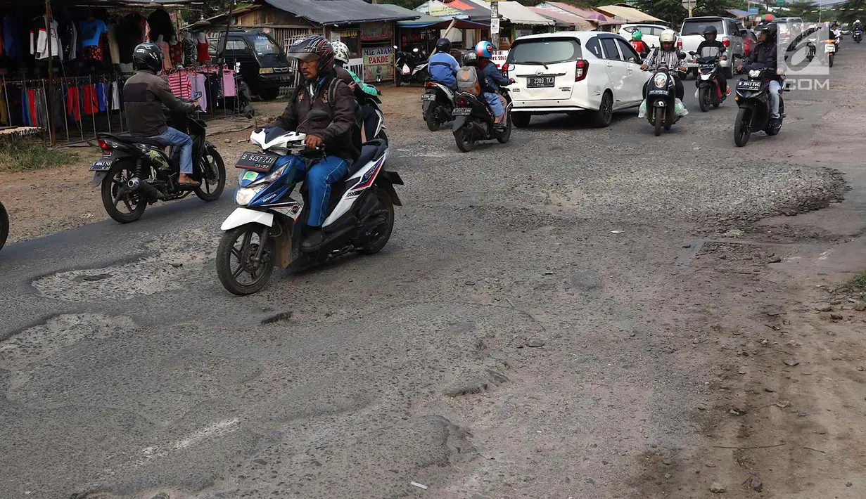 Lalu lalang kendaraan saat melintasi jalan berlubang di kawasan Gas Alam, Depok, Jawa Barat, Kamis (4/10). Jalan rusak di kawasan tersebut sudah berlangsung selama bertahun-tahun. (Liputan6.com/Immanuel Antonius)