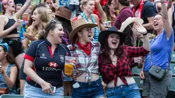 Sejumlah wanita bersorak saat menyaksikan hari pertama turnamen rugby sevens Hong Kong, China (6/4). Turnamen ini berlangsung selama tiga hari dan diselenggarakan setiap tahun oleh Hong Kong Rugby Union (HKRU). (AFP Photo/Isaac Lawrence)