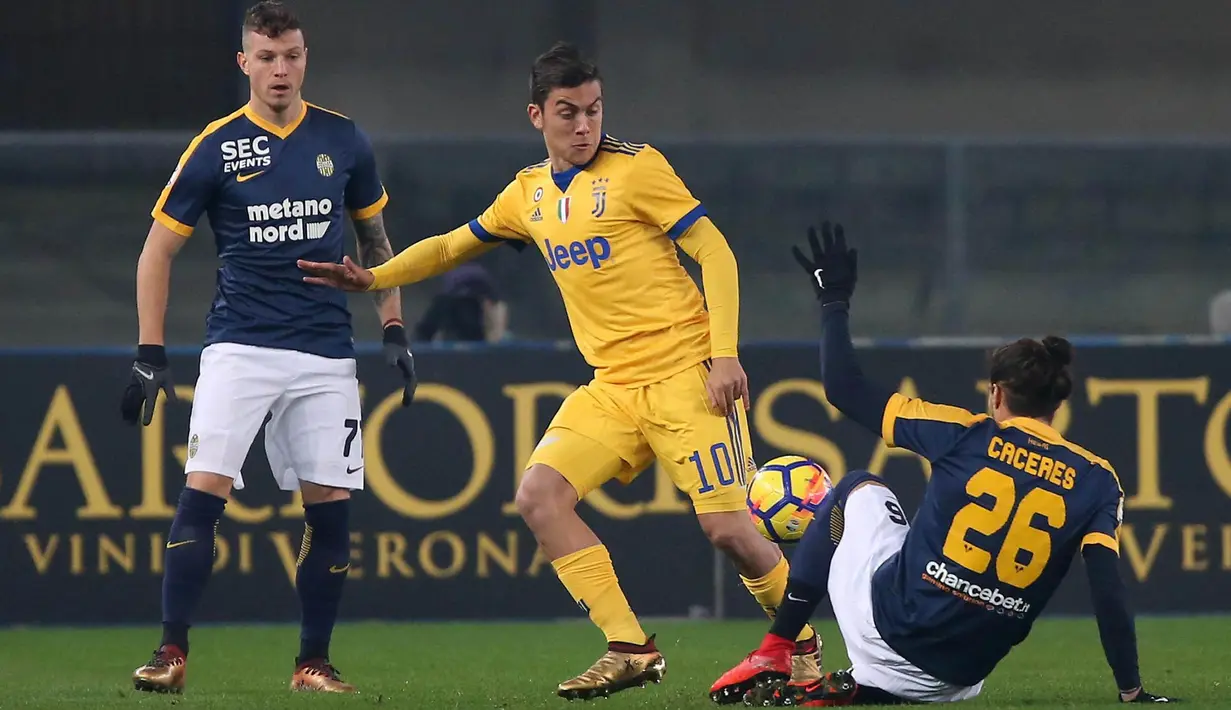 Striker Juventus, Paulo Dybala, berusaha melewati bek Hellas Verona, Martin Caceres, pada laga Serie A, Italia, di Stadion Marc'Antonio Bentegodi, Sabtu,(30/12/2017). Juventus menang 3-1 atas Hellas Verona. (AP/Filippo Venezia)