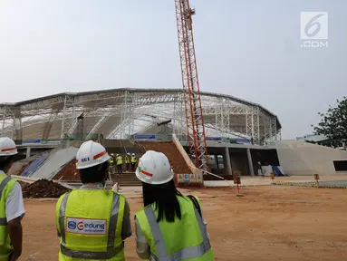 Pekerja melihat progres pembangunan stadion balap sepeda atau velodrom di Rawamangun, Jakarta, Jumat (3/11). Pembangunan velodrom bertaraf internasional ini sudah mencapai 68 persen dan ditarget selesai, Juni 2018. (Liputan6.com/Helmi Fithriansyah)