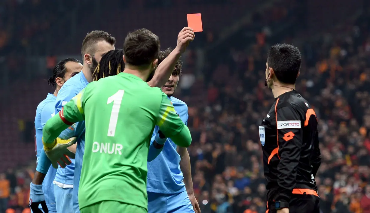 Pemain Trabzonspor, Salih Dursun, memberi kartu merah kepada wasit Deniz Bitnel (kanan) saat laga Liga Super Turki melawan Galatasaray di Istanbul, Turki, (21/2/2016). Salih Dursun sebelumnya mendapat kartu merah dari wasit. (Reuters/Str)