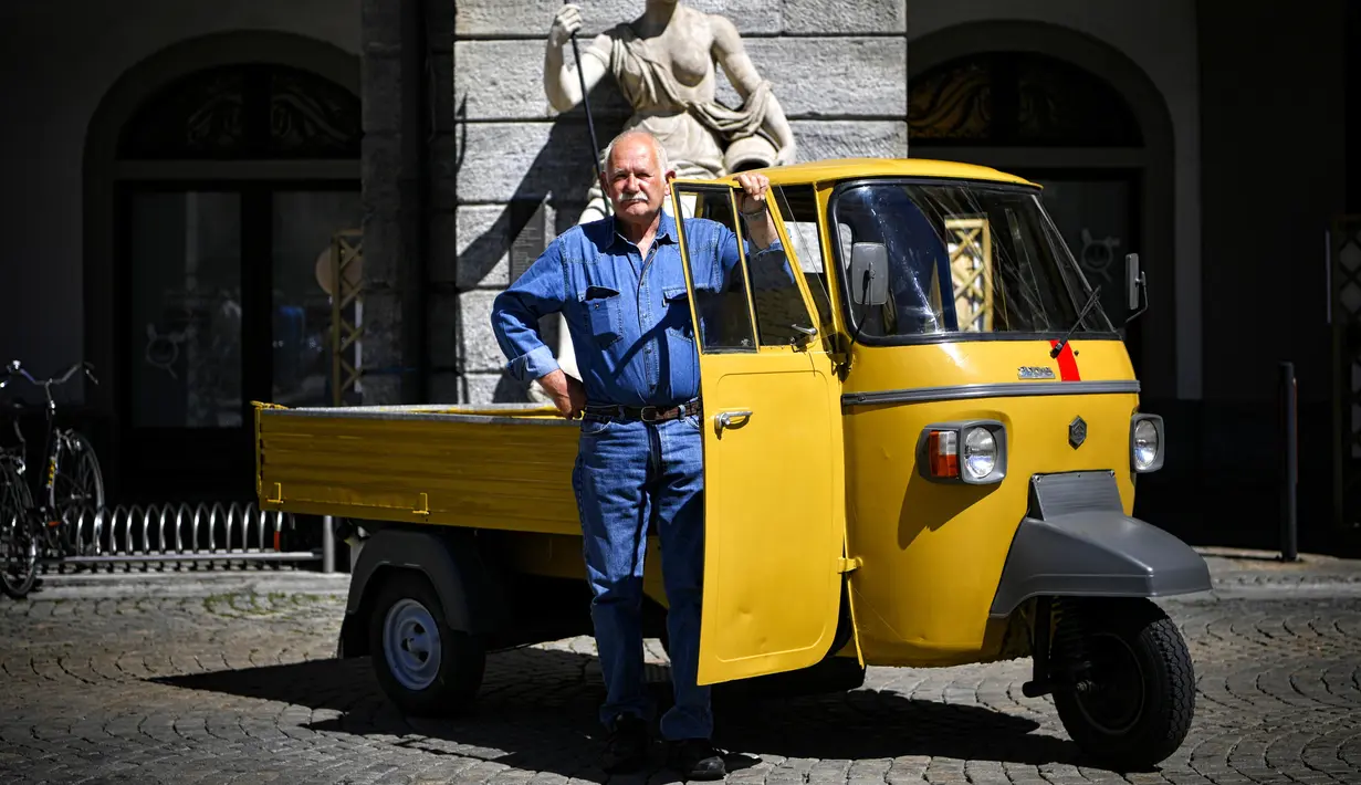 Seorang pria berpose dengan kendaraan Ape miliknya saat pameran memperingati 70 tahun Ape di Aosta, Italia utara (1/7). Piaggio Ape sendiri merupakan salah satu karya Corradino D’Ascanio insinyur yang juga merancang Vespa. (AFP Photo/Marco Bertorello)