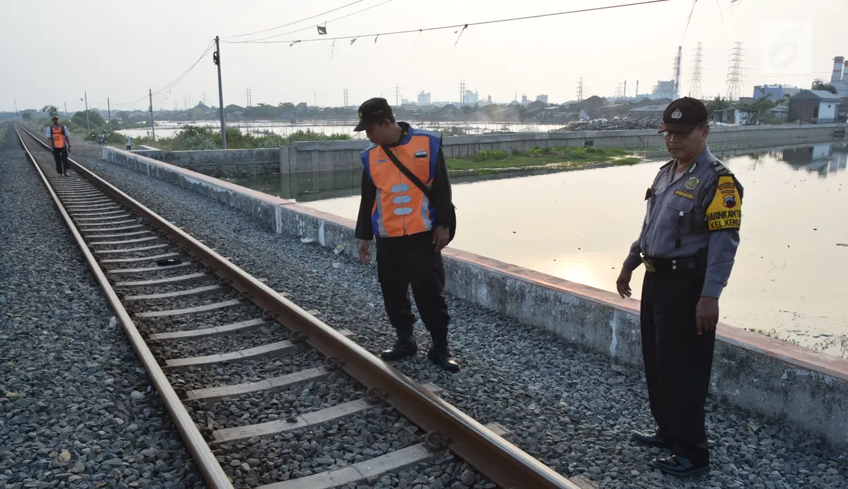 Petugas dari Polsuska dan Babinkamtibmas Kemijen Semarang  melakukan pemeriksaan rel kereta api di Jalur Kemijen, Minggu (3/6) . Pemeriksaan dilakukan secara ketat dan berkala untuk keamanan jalur kereta api selama arus mudik 2018. (Liputan6.com/Gholib)