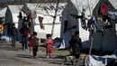 Anak-anak berjalan di sebuah kamp pengungsi Suriah di Turki yang didirikan oleh lembaga bantuan Turki AFAD di distrik Islahiye, Gaziantep, Turki, Rabu (15/2/2023). Gempa berkekuatan 7,8 magnitudo terjadi pada 6 Februari lalu dan meluluhlantakkan sebagian besar wilayah Turki dan Suriah. Jumlah korban tewas telah menembus 41.000 jiwa. (OZAN KOSE/AFP)