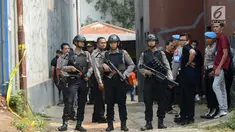 Polisi bersenjata berjaga-jaga saat berlangsungnya olah TKP di rumah terduga teroris di Nanggewer, Cibinong, Bogor, Jawa Barat, Sabtu (18/5/2019). Densus 88 Antiteror Mabes Polri menggelar olah TKP di rumah terduga teroris E alias Abu Rafi alias Pak Jenggot (51). (merdeka.com/Imam Buhori)