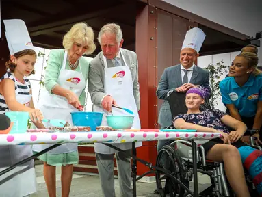 Pangeran Charles bersama sang istri Camilla Parker membuat kue lamington bersama anak-anak di Brisbane, Australia, Rabu (4/4). Kegiatan itu dilakukan dalam kunjungannya ke Rumah Sakit Anak Lady Cilento. (Patrick HAMILTON/POOL/AFP)