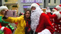 Seorang wanita berselfie dengan Santa Claus saat promosi musim Natal di distrik perbelanjaan di Seoul (13/11). Meski sebagian besar penduduknya adalah umat Budha, anak muda Korsel menikmati perayaan musim Natal tersebut. (AFP Photo/Jung Yeon-Je)