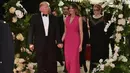 Melania Trump mendampingi Donald Trump saat menghadiri gala tahunan Palang Merah Amerika ke-60 di Mar-a-Lago, Florida, AS (4/2). First Lady Melania Trump tampil anggun dengan mengenakan gaun berwarna merah muda. (AFP/Mandel Ngan)