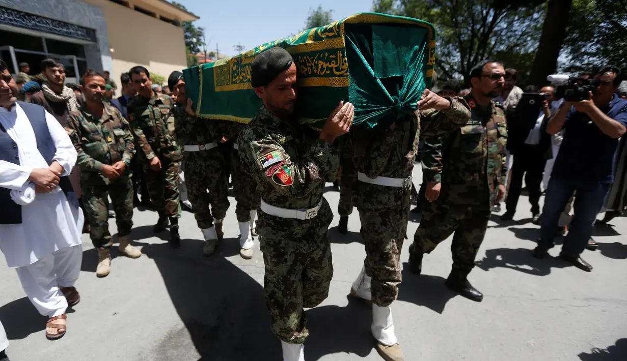 Tentara Nasional Afghanistan (ANA) membawa peti mati wartawan Zabihullah Tamanna dengan rekannya David Gilkey di sebuah rumah sakit di Kabul, Afghanistan (7 /6/2016). Tamanna merupakan seorang jurnalis yang sangat baik. (REUTERS/Omar Sobhani)