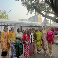 Happy Salma tampak menawan dibalut kebaya panjang bermotif bunga berwarna hijau lime dan selendang warna senada. [Instagram/mistertoton]