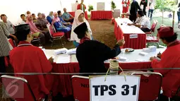Petugas KPPS mengenakan pakaian ala Betawi menunjukan surat suara kepada pemilih di TPS 31/32, Kelurahan Pondok Benda, Tangerang Selatan, Rabu (9/12). Surat suara berasal dari 2.245 TPS di seluruh Tangerang Selatan. (Liputan6.com/Fery Pradolo)