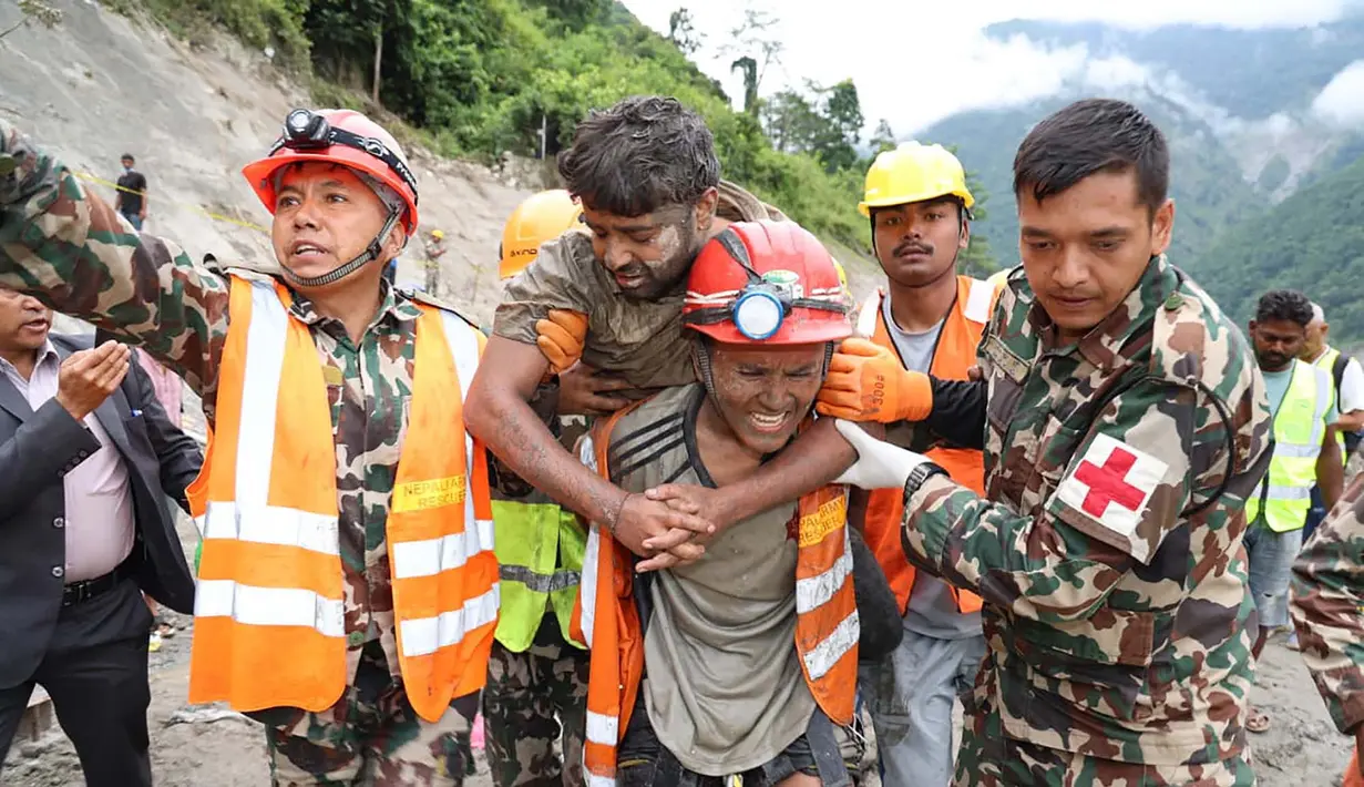 Para prajurit menyelamatkan seorang pekerja dalam keadaan hidup dari sebuah terowongan saat operasi yang sedang berlangsung di proyek pembangkit listrik tenaga air Trishuli-3A di distrik Rasuwa, Nepal, Jumat, 4 September 2026. (Angkatan Darat Nepal via AFP)