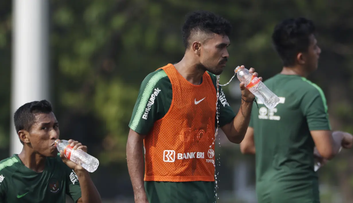 Pemain Timnas Indonesia U-22, Rifal Lastori, melepas dahaga saat latihan di Lapangan ABC Senayan, Jakarta, Senin (7/1). Latihan ini merupakan persiapan jelang Piala AFF U-22. (Bola.com/Vitalis Yogi Trisna)