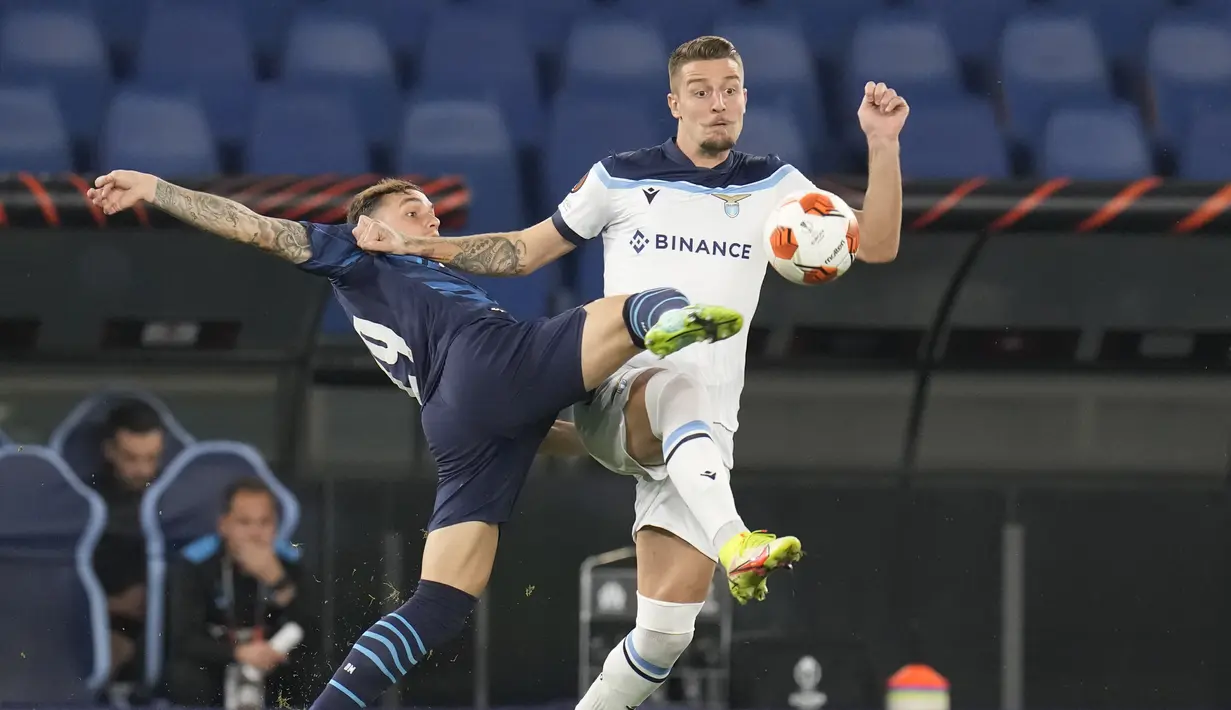 Bek Olympique Marseille, Pol Lirola berebut bola dengan gelandang Lazio Sergej Milinkovic-Savic pada matchday kedua Grup E Liga Europa 2021 di Stadion Olimpico Roma, Kamis (21/10/2021) malam WIB. Lazio hanya mampu bermain imbang 0-0 kala menjamu Marseille. (AP Photo/Gregorio Borgia)