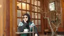 Natasha Rizky tampil dengan jaket hijau dipadukan inner dan rok hitam, senada dengan kerudungnya. Ia pun mengenakan kacamata hitam. Dipadukan sepatu Puma hitam.  [@natasharizkynew]