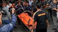 Jenazah salah satu korban kecelakaaan maut Kereta Commuter Line dan Metro Mini di perlintasan kereta Angke, Tambora, Jakarta, Minggu (6/12/2015). Data sementara korban meninggal bertambah menjadi 18 orang. (Liputan6.com/Gempur M Surya)