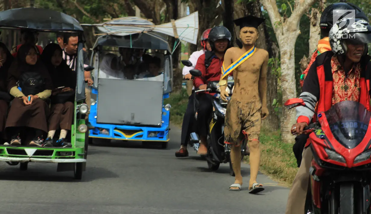 Mahasiswa UniversItas Gorontalo, Indra Nodu melakukan aksi jalan kaki dari kampus ke rumahnya di Desa Posso, Gorontalo Utara, 4 Agustus 2018. Aksi itu untuk memenuhi nazarnya karena telah berhasil menyelesaikan studi S1. (Liputan6.com/Arfandi Ibrahim)
