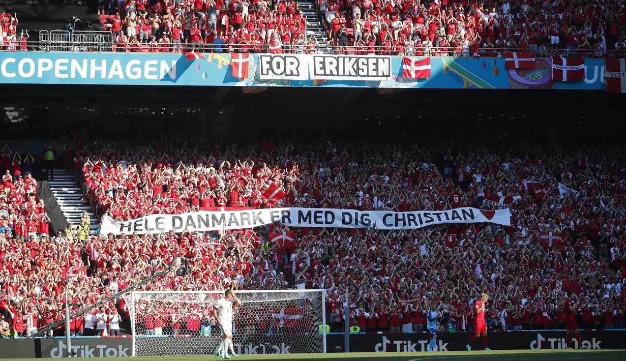 Suporter timnas Denmark memasang spanduk untuk Christian Eriksen pada laga grup B Euro 2020 di stadion Parken, Kopenhagen, Kamis (17/6/2021). Duel Denmark vs Belgia berhenti sejenak pada menit ke-10 untuk memberi penghormatan kepada bintang timnas Denmark, Christian. (Wolfgang Rattay, Pool via AP)