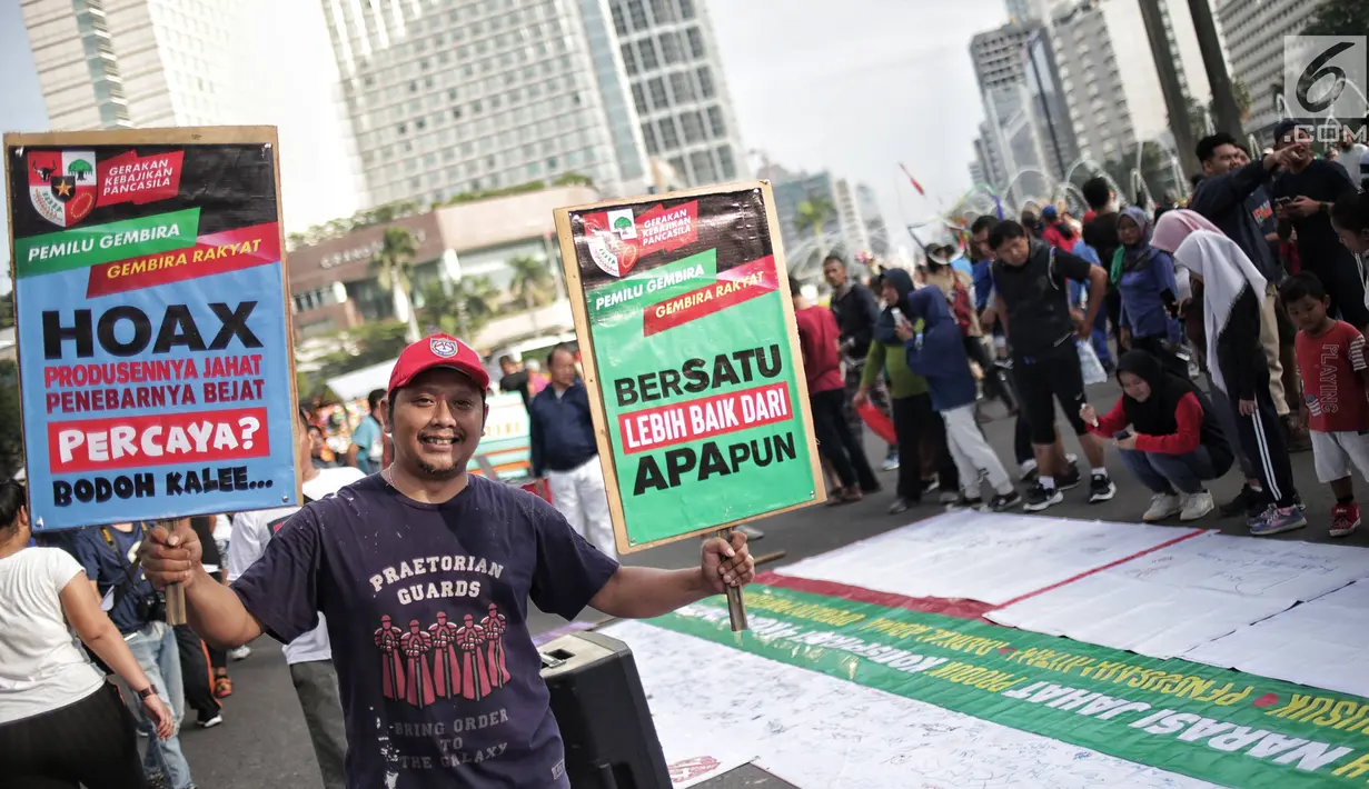 Relawan Gerakan Kebajikan Pancasila mengangkat poster saat meggelar aksi Pemilu Gembira Melawan Hoax di Bundaran HI, Jakarta, Minggu (3/1). Gerakan ini mengajak masyarakat untuk mewujudkan demokrasi beradab jelang Pemilu. (Liputan6.com/Faizal Fanani)