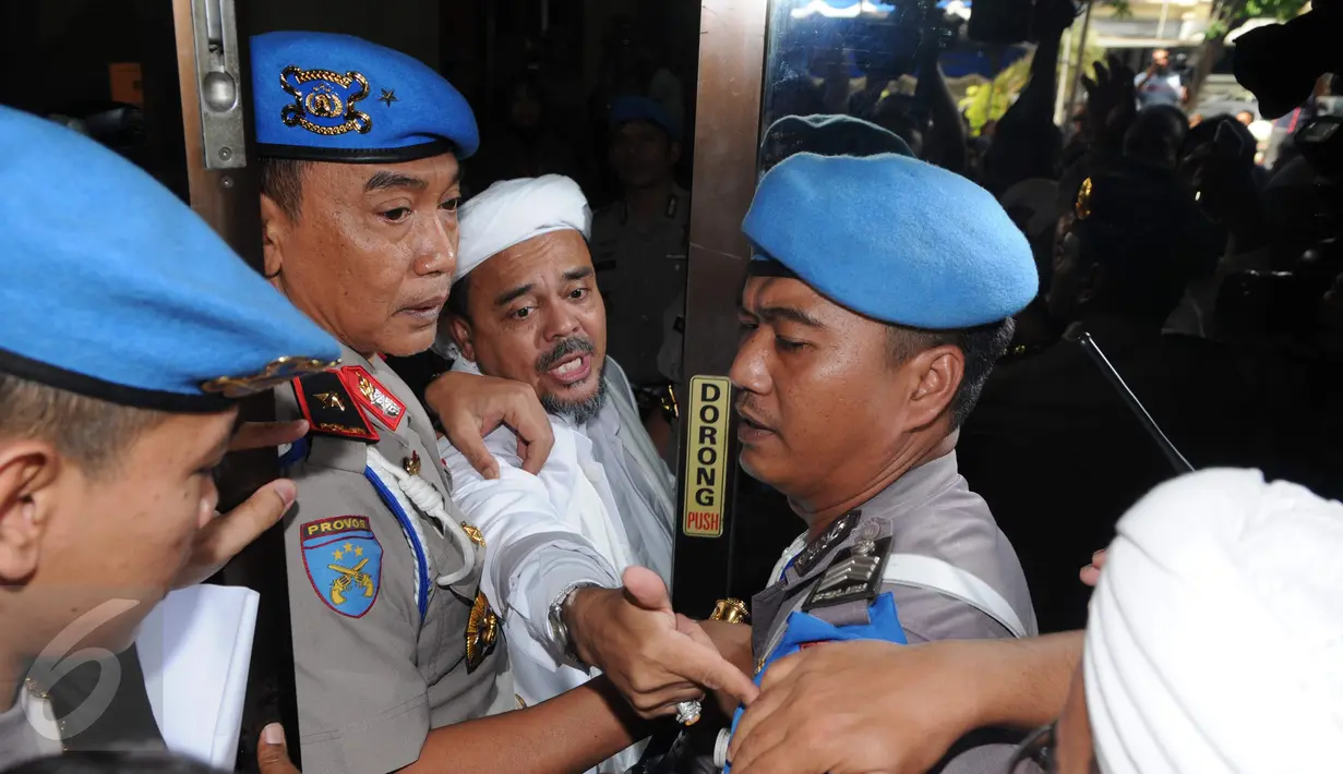 Ketua FPI Habib Rizieq saat masuk ke dalam Gedung Rupatama menghadiri gelar perkara terbuka kasus dugaan penistaan agama oleh Basuki T Purnama, Jakarta, Selasa (15/11). Rizieq menjadi saksi ahli dari pihak pelapor. (Liputan6.com/Helmi Afandi)