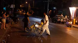 Seorang wanita yang berada di atas kursi roda terlihat dievakuasi setelah gempa bumi berkekuatan 4,9 skala richter kembali mengguncang Managua, Minggu malam (13/4/2014) waktu setempat. (REUTERS/Jorge Cabrera)