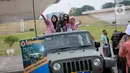 Warga berfoto di atas kendaraan milik TNI saat pameran alat utama senjata (alutsista) di Lapangan Monumen Nasional (Monas) Jakarta, Minggu (24/9/2023). (Liputan6.com/Faizal Fanani)