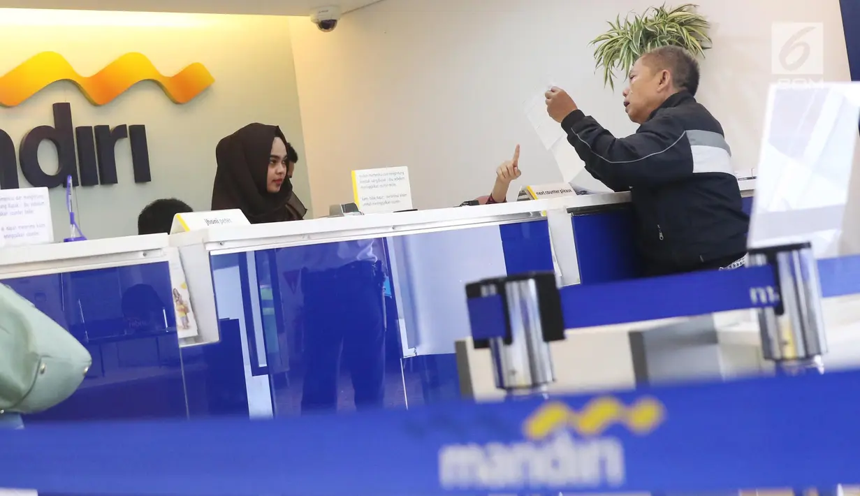 Nasabah melakukan transaksi di cabang Bank Mandiri Pertamina UPMS III, Jakarta, Rabu (28/6). Bank Mandiri memberikan layanan perbankan terbatas kepada nasabah secara bergantian pada musim liburan Idul Fitri 26-30 Juni 2017. (Liputan6.com/Angga Yuniar)