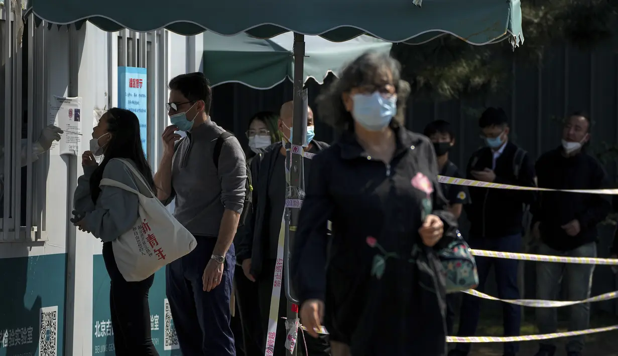 Warga mengantre untuk mendapatkan swab tenggorokan COVID-19 rutin mereka di tempat pengujian virus corona di Beijing, Kamis (6/10/2022). Xinjiang yang luas adalah wilayah China terbaru yang terkena pembatasan perjalanan COVID-19, karena China semakin meningkatkan langkah-langkah pengendalian menjelang kongres penting Partai Komunis akhir bulan ini. (AP Photo/Andy Wong)