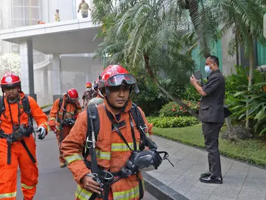 Petugas berlarian saat berusaha memadamkan kebakaran di Gedung Cyber 1, Jakarta, Kamis (2/12/2021). Sampai saat ini, penyebab kebakaran masih belum diketahui. (Liputan6.com/Herman Zakharia)