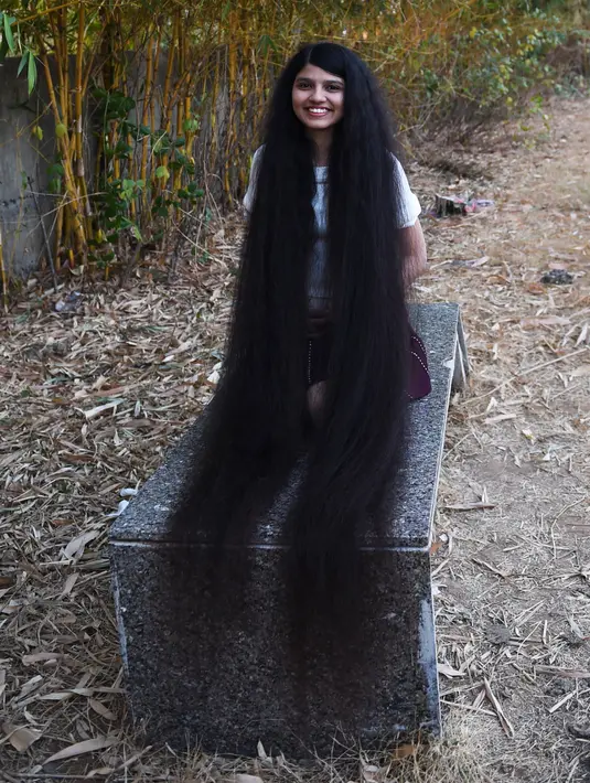 Gadis asal India, Nilanshi Patel (17) berpose untuk foto di kota Modasa, Ahmedabad, Minggu (19/1/2020). Pada 2018, Patel mencatatkan dirinya dalam daftar Guinness World Records pada kategori yang sama, yaitu pemilik rambut terpanjang di dunia dengan panjang hingga 170,5 cm. (SAM PANTHAKY/AFP)