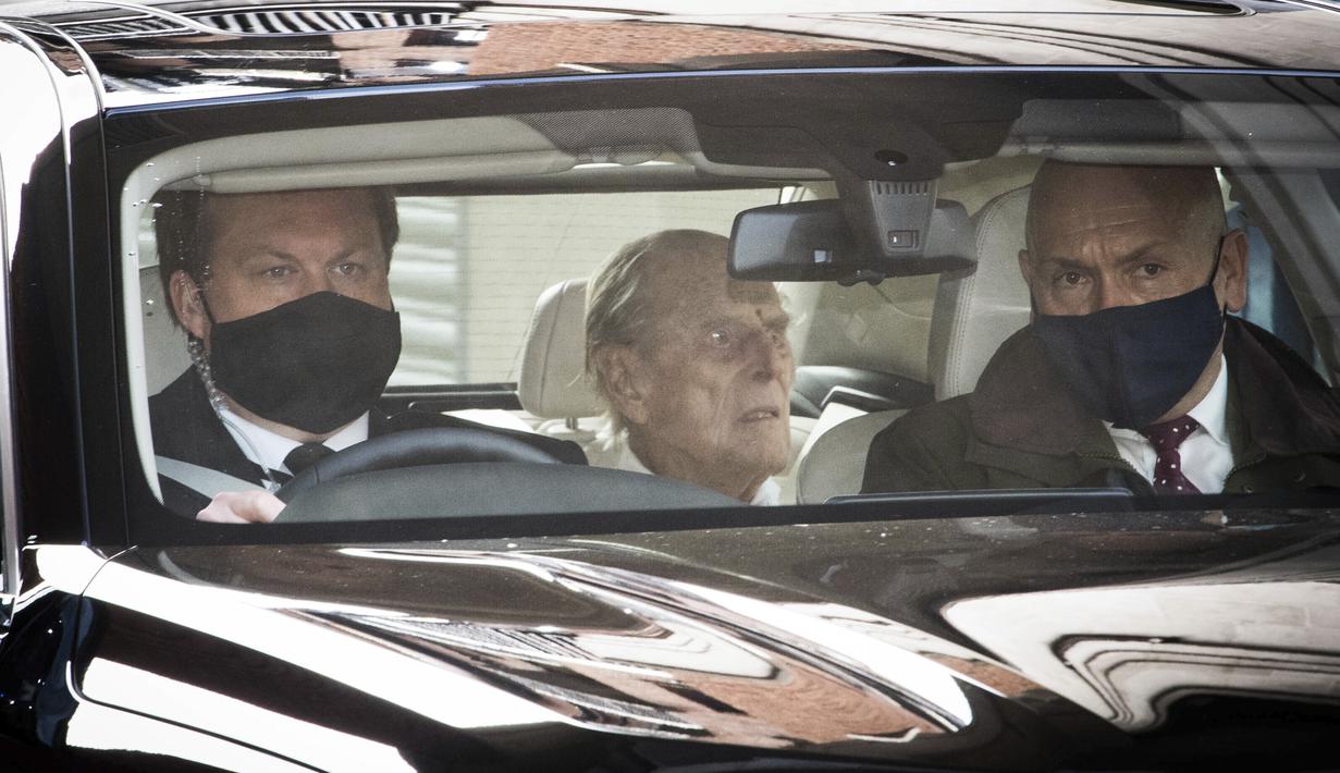Pangeran Philip (tengah) berada di dalam mobil saat meninggalkan rumah sakit Prince Edward VII di London, Selasa (116/3/2021). Suami Ratu Elizabeth II yang berusia 99 tahun itu dirawat di rumah sakit selama empat pekan terkait infeksi dan operasi jantung. (Stefan Rousseau/PA via AP)