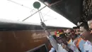 Menaker Hanif Dhakiri (kiri) menyilakan kereta api untuk berangkat di Stasiun Pasar Senen, Jakarta, Jumat (1/5). Menaker memperingati Hari Buruh se-Dunia (May Day) dengan mengangkat tema "Bersih-bersih BUMN". (Liputan6.com/Herman Zakharia)